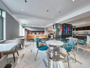 a dining room with tables and blue chairs at Magnotel Business Shanghai Minhang Wujing East China Normal University in Shanghai