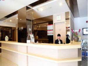 Un uomo seduto al bancone in un ristorante di Jinjiang Inn Wuxi Li Lake Yauntouzhu Scenic Spot a Wuxi