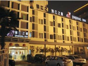 a building with cars parked in front of it at Jinjiang Inn Wuxi Li Lake Yauntouzhu Scenic Spot in Wuxi