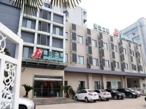 a building with cars parked in front of it at Jinjiang Inn Wuxi Li Lake Yauntouzhu Scenic Spot in Wuxi