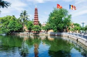 a pond in front of a building with two flags at Cong Doan Viet Nam Hotel in Hanoi