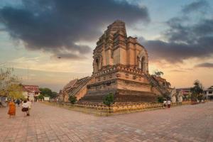 Un gran edificio con gente caminando frente a él. en OYO 794 Nice Mum Lodge, en Chiang Mai