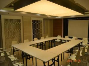 ein Konferenzraum mit weißen Tischen und Stühlen und einer Leinwand in der Unterkunft Jinjiang Inn Tianjin South Station in Tianjin