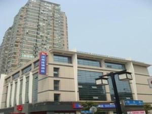 ein großes Gebäude mit einem Schild davor in der Unterkunft Hanting Hotel Wuxi Taihu Lake Plaza Branch in Wuxi