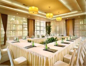 Habitación grande con mesas largas y sillas blancas. en Hillview Golf Resort Dongguan, en Dongguan