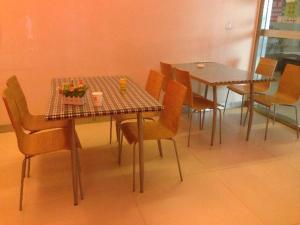 a dining room with two tables and chairs at 7 Days Inn Shantou High-Speed Railway Station Zhujiang Road Food Street in Ma Yu