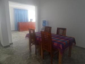 米瑞莎Coralworld Hotel的餐厅里有一张桌子和椅子，蓝色和紫色