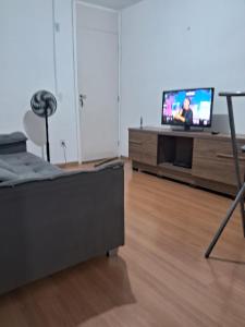 un salon avec un lit et une télévision dans l'établissement Apto Oeste simples Santa cruz, à Rio de Janeiro