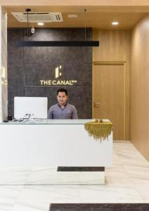 a man standing behind a counter in a lobby at The Canal 304 in Si Maha Phot +110 photos