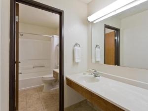 a bathroom with a sink and a toilet and a mirror at Super 8 By Wyndham Lexington Park/California Area in California +8 photos