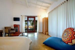 a living room with a blue couch in a room at Sri lanka Beach House Hotel in Degalla