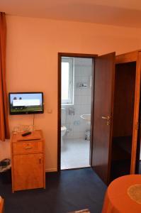 a bathroom with a television and a bathroom with a toilet at Steens Hotel in Hamburg