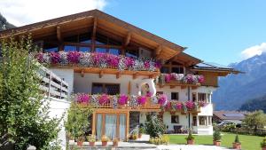a building with flower boxes on the side of it at Landhaus Alpensonne in Neustift im Stubaital