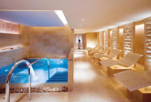 香港The Landmark Mandarin Oriental Hong Kong的游泳池位于酒店带椅子和浴缸的客房