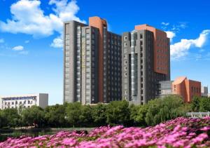 a city with pink flowers in front of buildings at Dajiuhua Hotel in Chizhou