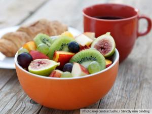 un bol de fruits orange avec une tasse de café dans l'établissement Ibis Lianyungang Guanyun County Downtown Hotel Hotel, à Guanyun 64 autres photos
