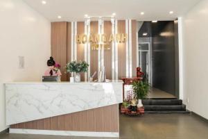 a woman sitting at a counter in a lobby at Hoang Anh Hotel Vung Tau in Vung Tau