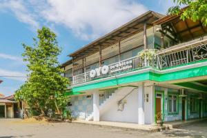 a building with a balcony on top of it at OYO 1755 De'balcon Accomodation Near Ngurah Rai Airport in Ubud