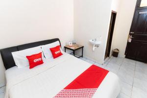 - une chambre avec un lit doté d'oreillers rouges et d'un lavabo dans l'établissement Hotel O Wisma Pelita Mas, à Pampang