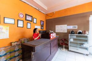 PampangにあるHotel O Wisma Pelita Masのファーストフード店のカウンターに座る女
