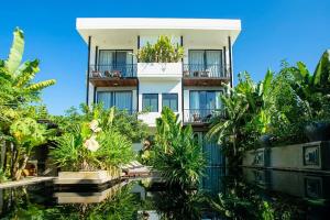 Un bâtiment avec beaucoup de plantes devant lui dans l'établissement K.K inn Boutique Siem Reap, à Siem Reap