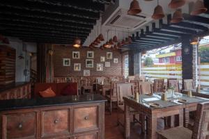 a restaurant with tables and chairs in a room at Capital O 697 Swornim Boutique Hotel in Thapathali