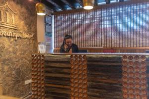 a woman sitting at a bar in a restaurant at Capital O 697 Swornim Boutique Hotel in Thapathali