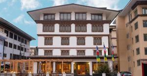 a large white building with flags in front of it at Lemon Tree Hotel Thimphu in Thimphu