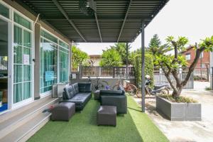 a patio with couches and chairs on the grass at OYO 75305 T Park Pak Chong in Mu Si