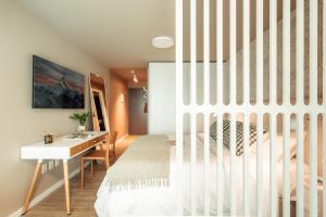 una camera da letto con un letto bianco e una scrivania di ZENHAUS - Punta Carretas Moderno y con Vistas Despejadas a Montevideo