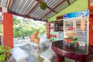 a room with a table and benches in a store at OYO 75372 Flight hut hotel in Hua Hin