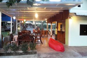 un patio avec une table et des chaises et un restaurant dans l'établissement OYO 75380 Bannoichynum Resort Kanchanaburi, à Ban Tha Kilen (1)