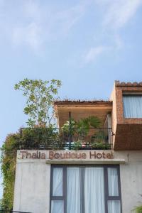 a hotel sign on the side of a building at Thalia Boutique Hotel Hoian in Hoi An