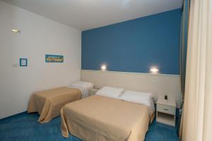 マイオーリにあるOasiの青い壁の客室で、ベッド2台が備わります。
