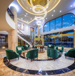 eine Lobby mit grünen Stühlen und einem Kronleuchter in der Unterkunft Da Lat Prince in Khu Chi Lăng