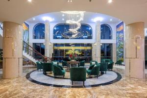 eine Lobby mit grünen Stühlen und einem Kronleuchter in der Unterkunft Da Lat Prince in Khu Chi Lăng