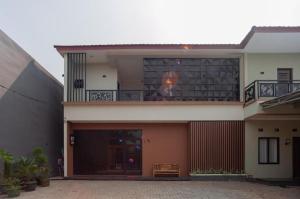 a large house with a balcony on top of it at Hanna Residence near RSPI Puri Indah Mitra RedDoorz in Meruya-hilir