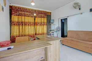 a living room with a couch and a table in a room at Hotel O Mutiara Homestay Syariah Near TPA / TPSA Nurul Yakin in Sarilamak