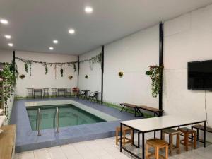 einen Pool in einem Zimmer mit einem Tisch und einem Tisch in der Unterkunft Rakchayanin Resort Koh Larn in Ko Larn