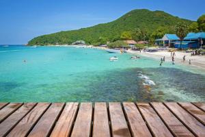 Blick auf einen Strand mit Menschen im Wasser in der Unterkunft Rakchayanin Resort Koh Larn in Ko Larn