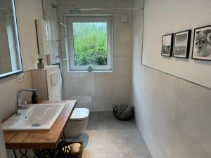 a bathroom with a toilet and a sink and a window at Hafenglück Friedrichskoog in Friedrichskoog