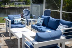 ポート・シャーロットにあるHouse With A Boat - Boat, Heated Pool, Sup Boardsの青い椅子とテーブルが並ぶパティオ