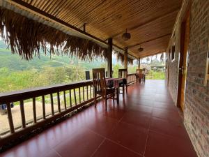 a porch of a house with chairs and a table at Sapa Hmong Bungalow Homestay in Sa Pa +39 photos