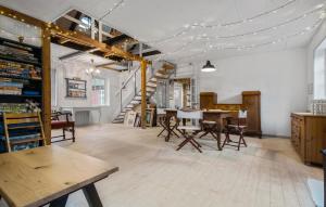 ein Raum mit einem Tisch und Stühlen und einer Treppe in der Unterkunft Stunning Home In Sjællands Odde in Yderby