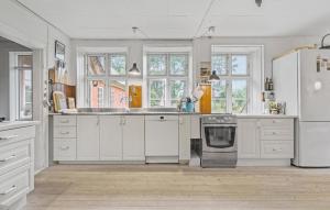eine Küche mit weißen Schränken und einem Herd mit Backofen in der Unterkunft Stunning Home In Sjællands Odde in Yderby