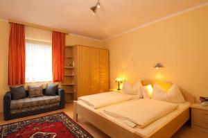 a bedroom with a large bed and a chair at Pension Jägerhof in Mallnitz