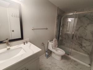 a bathroom with a sink and a toilet and a shower at Tom oker in Mississauga