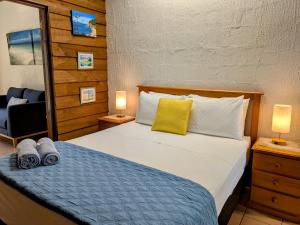 a bedroom with a bed and a chair and two lamps at Beachside Cottage - A Private Peaceful Hidden Gem 50m to Beach in Nelly Bay +27 photos
