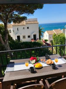 a table with food and drinks on a balcony with the ocean at Donalolaplaya in Mijas Costa