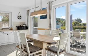 a kitchen and dining room with a wooden table and chairs at Nice Home In Glowe With Wifi in Glowe